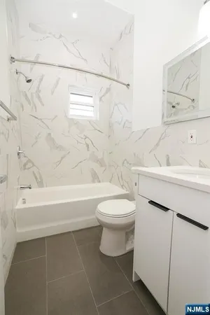 a bathroom with a toilet sink vanity tub and shower