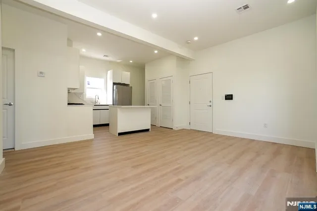 a view of a kitchen with a sink and a refrigerator