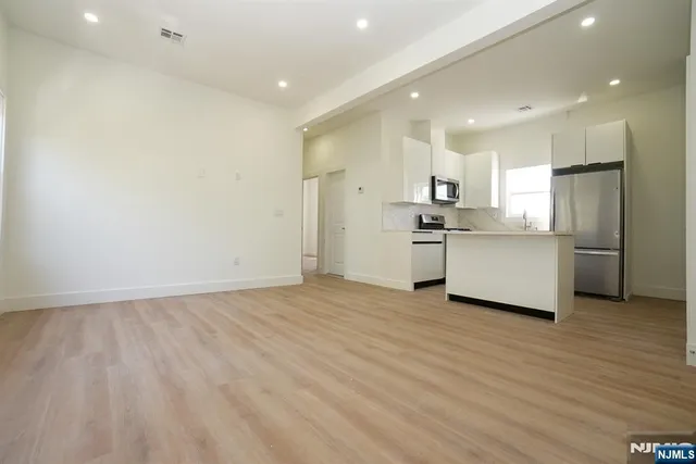 a view of a kitchen with a sink and wooden floor