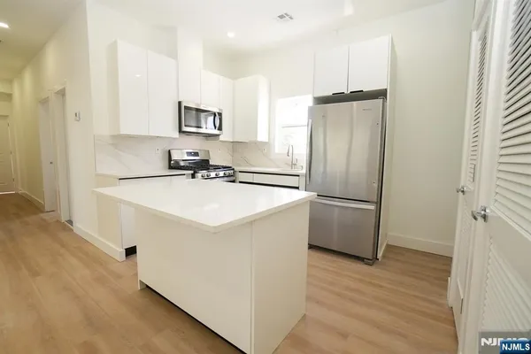a kitchen with a sink refrigerator and microwave