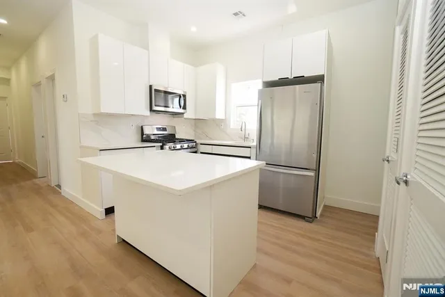 a kitchen with a sink refrigerator and microwave