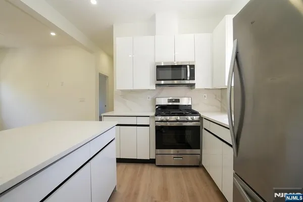 a kitchen with stainless steel appliances a sink a stove a microwave and cabinetry