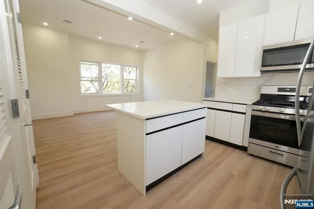 a kitchen with granite countertop white cabinets and white appliances