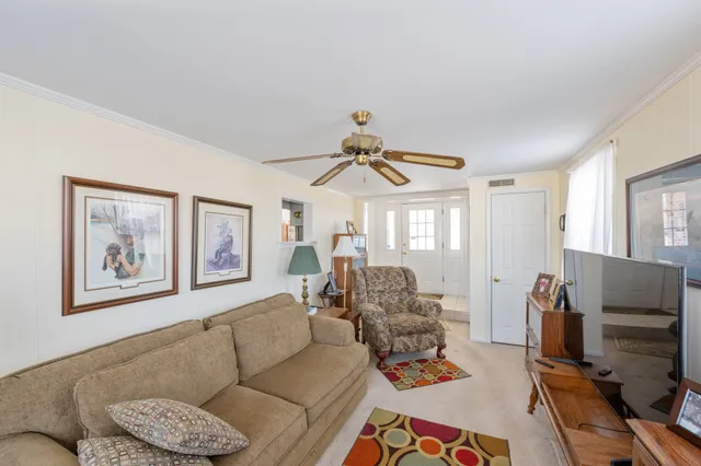 a living room with furniture a flat screen tv and a window