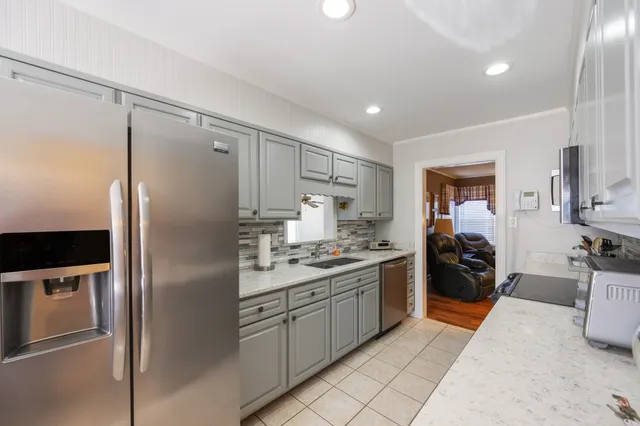 a kitchen with stainless steel appliances granite countertop a refrigerator and a sink