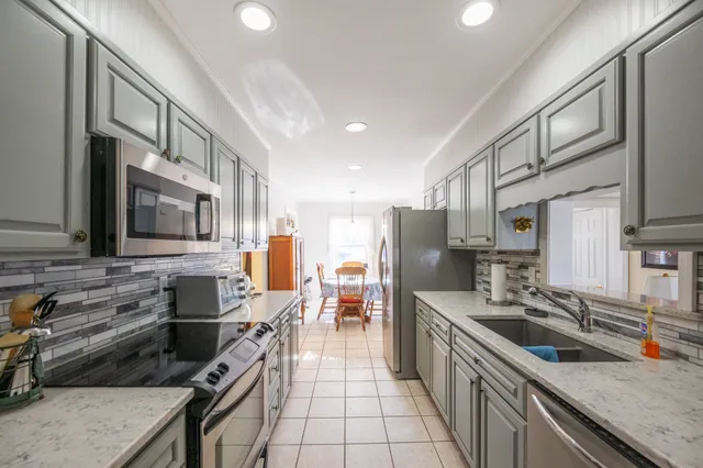 a kitchen with stainless steel appliances a stove a sink and a refrigerator