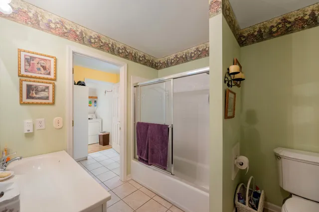 a bathroom with a granite countertop sink a mirror a toilet and shower