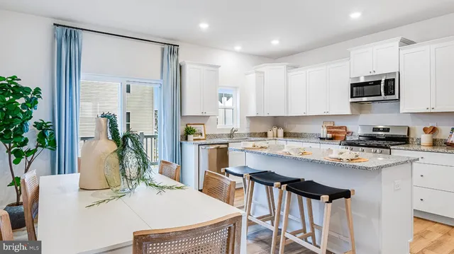 a kitchen with stainless steel appliances granite countertop a stove a sink a microwave a refrigerator and cabinets