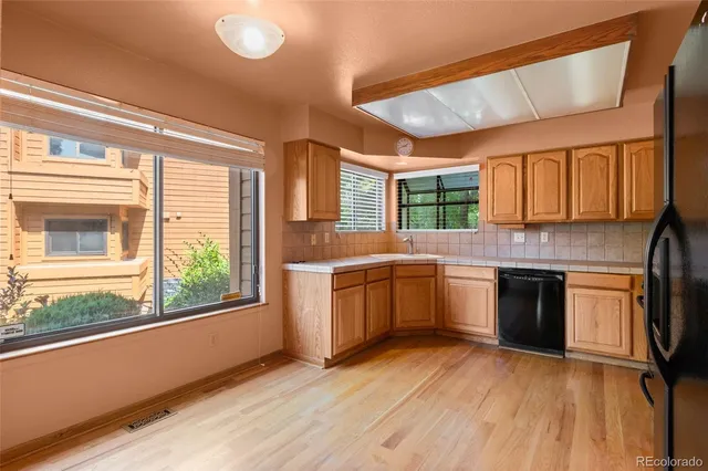a kitchen with granite countertop wooden floors and stainless steel appliances