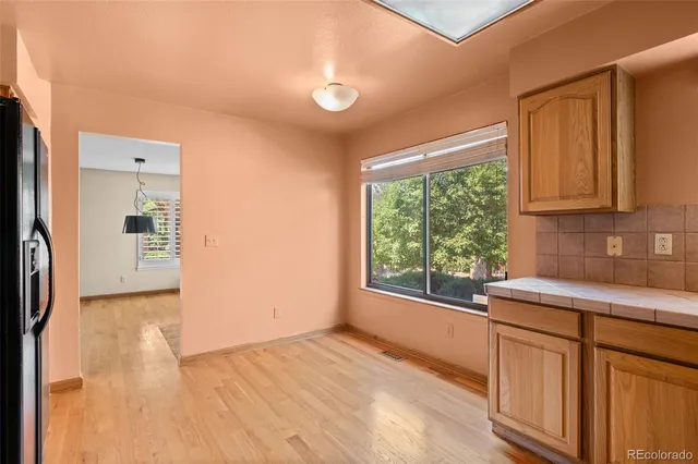 a view of a kitchen with a sink and dishwasher with wooden floor