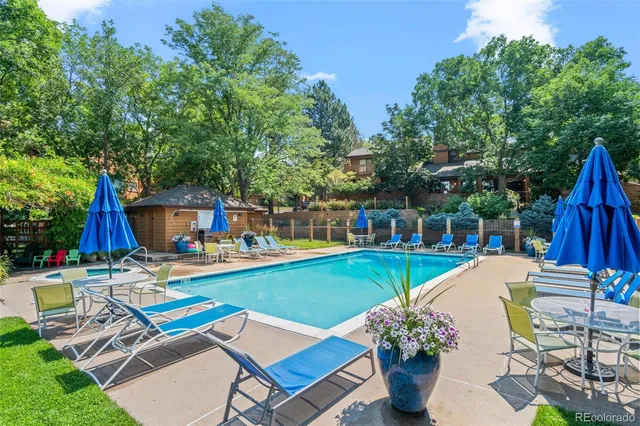 a view of a swimming pool with a lawn chairs under an umbrella
