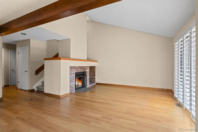 a view of a livingroom with wooden floor and a fireplace