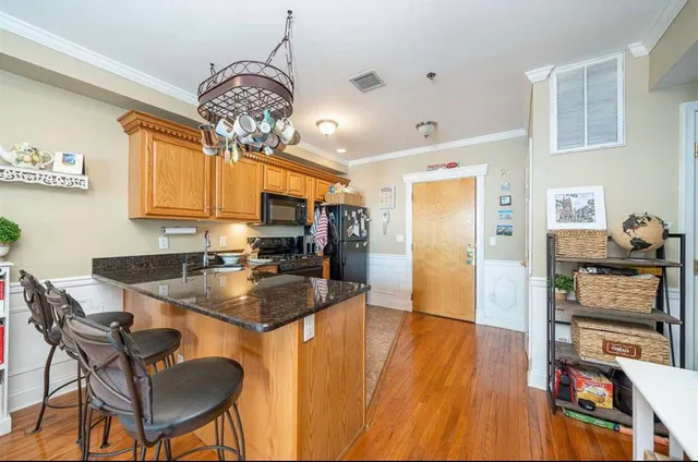 a dining room filled chandelier and wooden floor