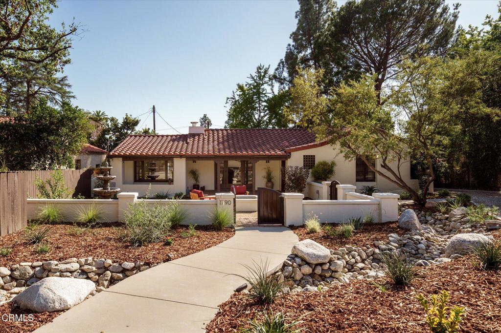 a front view of a house with garden and sitting area