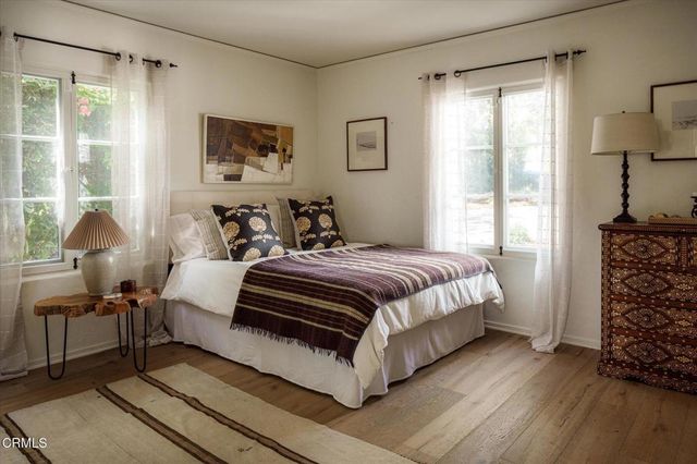 a bedroom with a bed and a dresser next to a window