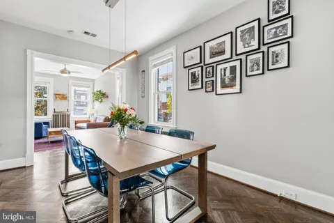 a kitchen with granite countertop a refrigerator a stove and a wooden floor