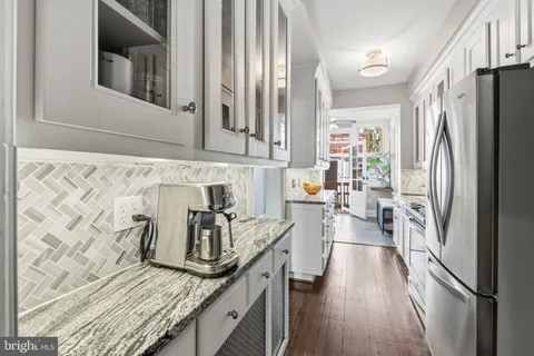 a kitchen with stainless steel appliances a sink dishwasher and cabinets with wooden floor
