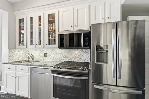 a kitchen with stainless steel appliances granite countertop a sink and cabinets