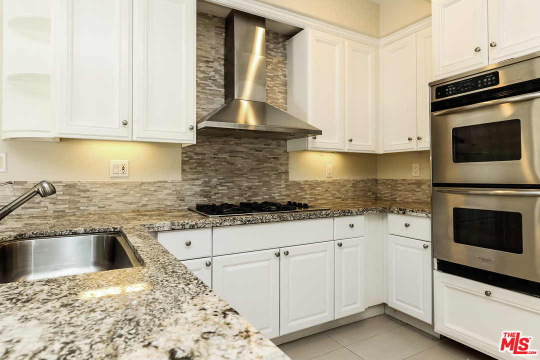 6 Alamitos Foothill Ranch, CA 92610 - Photo 11 of 27 a kitchen with granite countertop white cabinets and white appliances