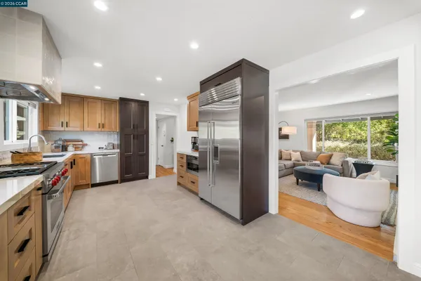 a kitchen with stainless steel appliances granite countertop a refrigerator and a stove top oven