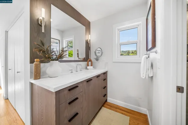 a bathroom with a sink vanity granite and a mirror