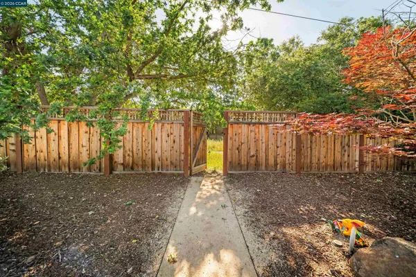 a view of backyard with wooden fence and trees