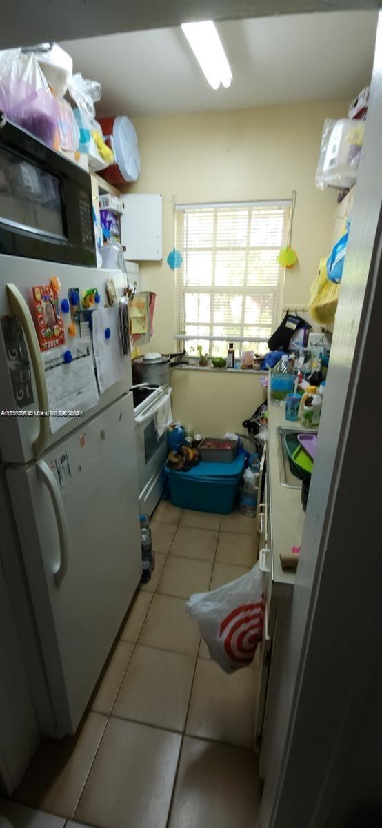 251 Northwest 34th Terrace Miami, FL 33127 - Photo 10 of 12 a kitchen with lots of clutter and cabinets