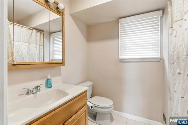 a bathroom with a sink vanity granite toilet and a window