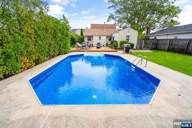 a swimming pool with yard in the back