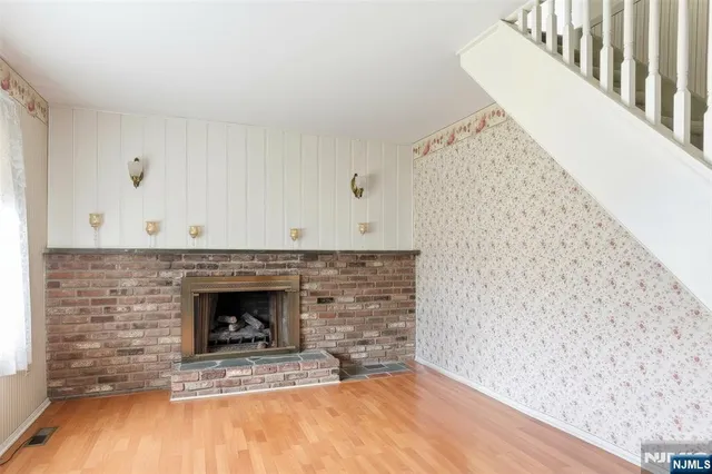 a view of empty room with wooden floor and fireplace