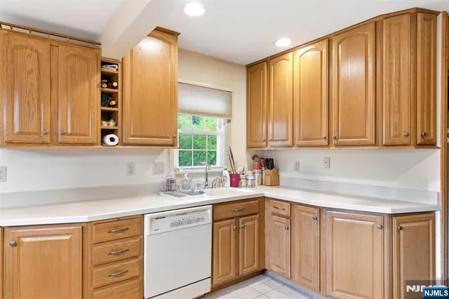 a kitchen with stainless steel appliances white cabinets and a window