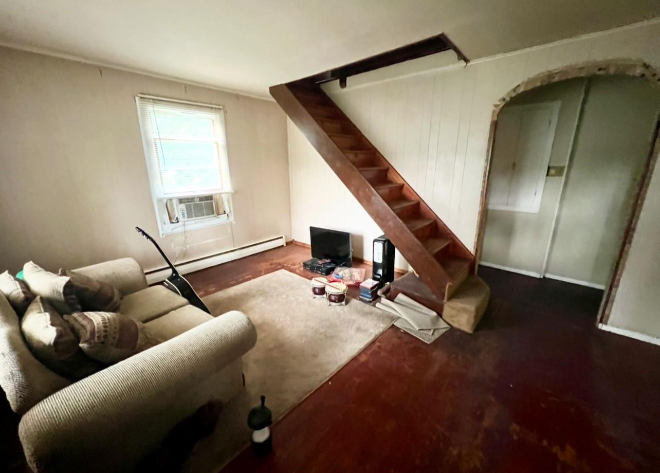 100 Maple Lane Medford, NY 11763 - Photo 5 of 13 Living room featuring baseboard heating, stairs, and arched walkways