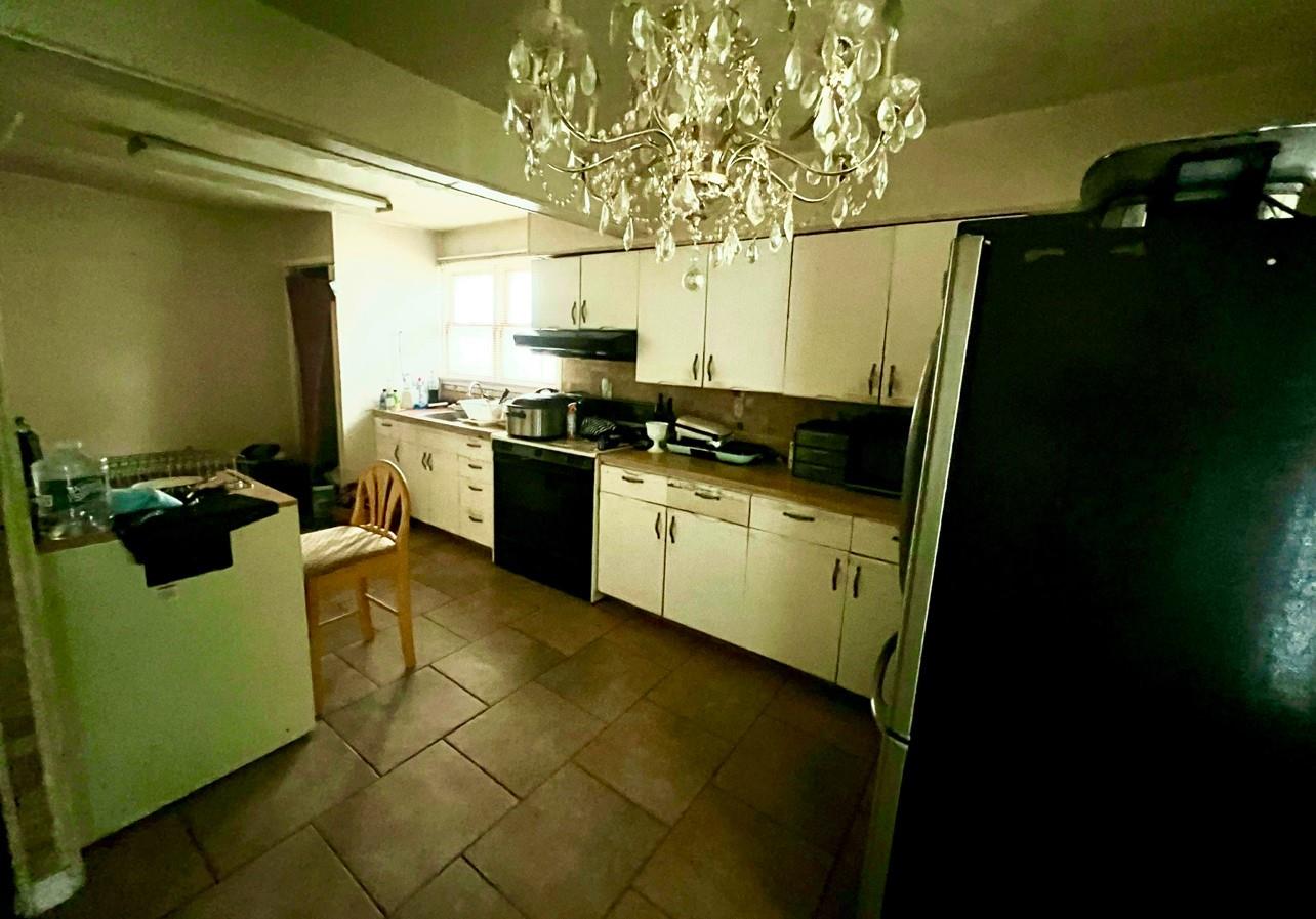 100 Maple Lane Medford, NY 11763 - Photo 7 of 13 Kitchen featuring freestanding refrigerator, white cabinetry, black range with electric stovetop, a chandelier, and under cabinet range hood