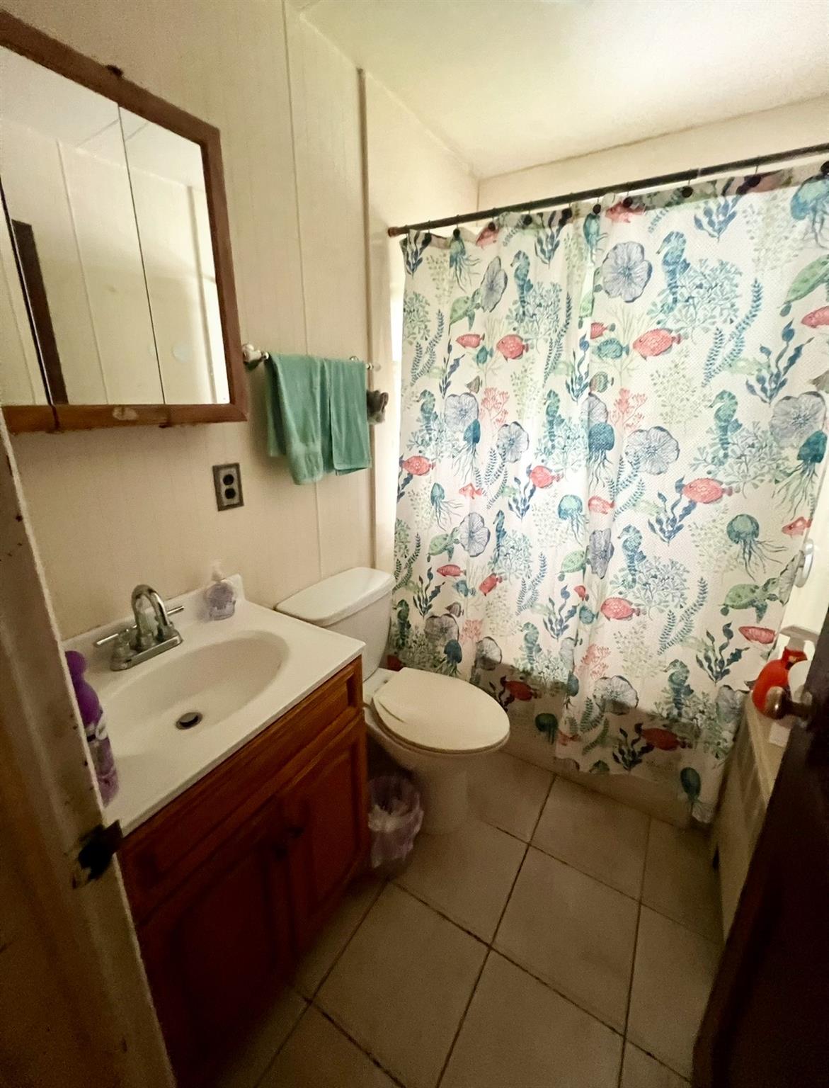100 Maple Lane Medford, NY 11763 - Photo 8 of 13 Bathroom with vanity, tile patterned flooring, and curtained shower