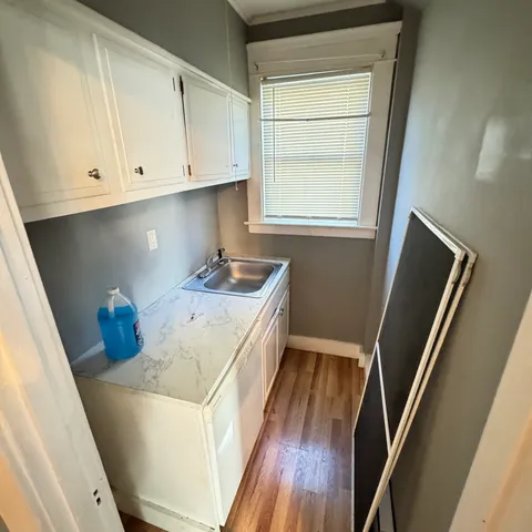 a kitchen with sink cabinets and wooden floor