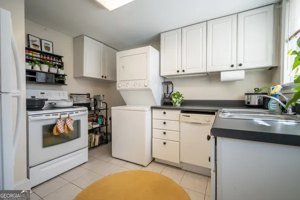 a kitchen with white cabinets and appliances