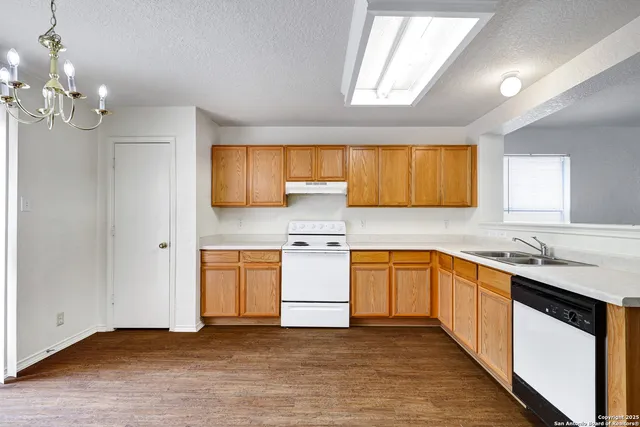 a kitchen with stainless steel appliances granite countertop a sink stove and cabinets