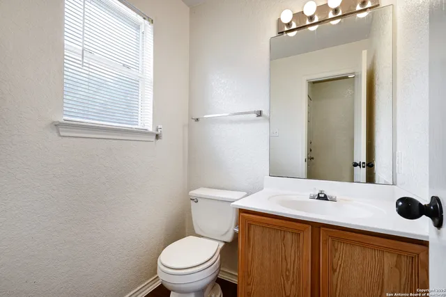 a bathroom with a sink a toilet and mirror