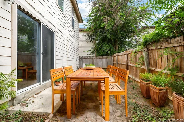 a view of a patio with table and chairs potted plants with wooden fence