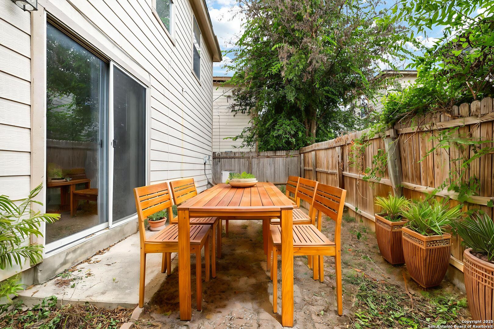8014 Sandbar San Antonio, TX 78254 - Photo 27 of 30 a view of a patio with table and chairs potted plants with wooden fence