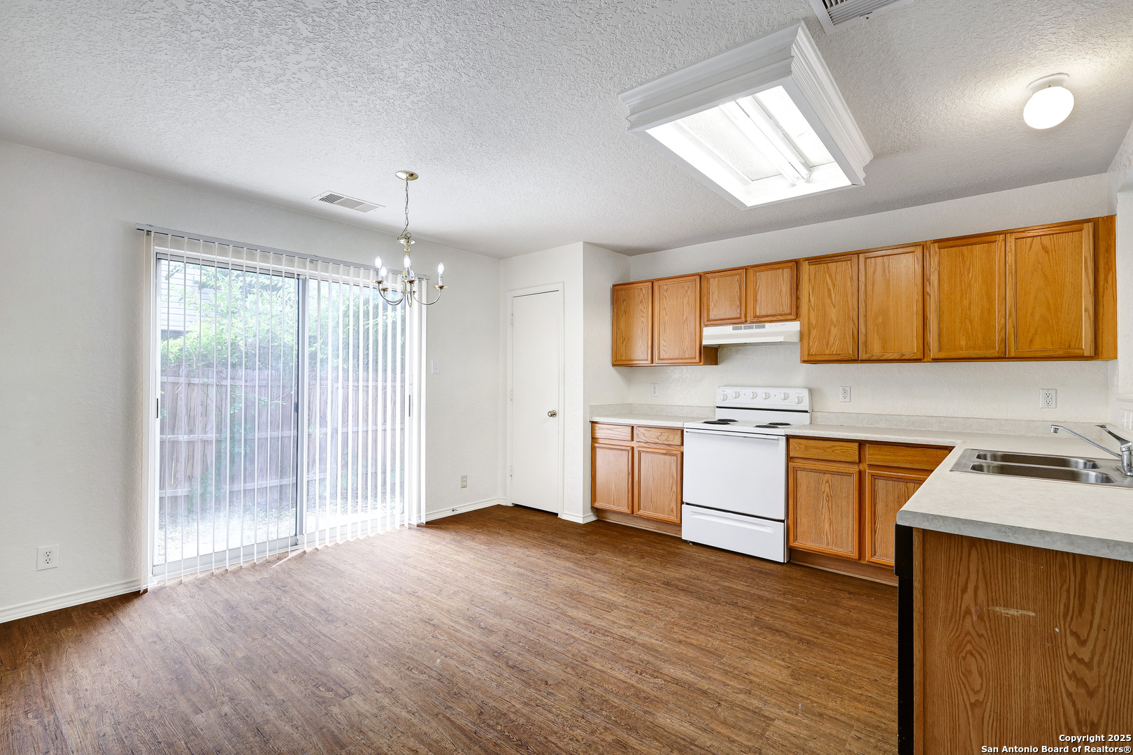 8014 Sandbar San Antonio, TX 78254 - Photo 9 of 30 a kitchen with stainless steel appliances granite countertop wooden cabinets a stove a sink and dishwasher with wooden floor