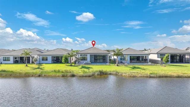 a front view of a house with a garden and lake view