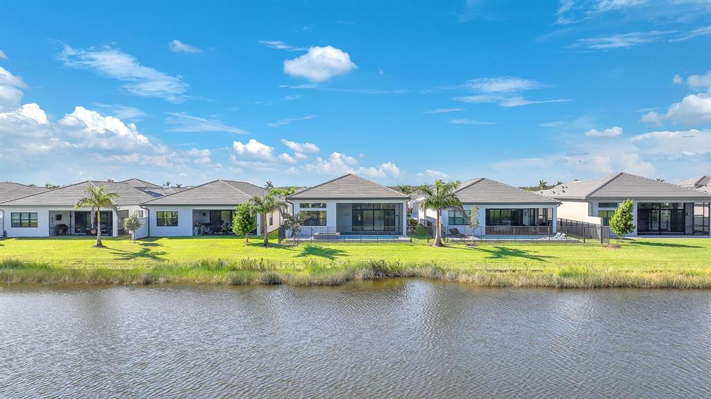 10990 Violet Mdw Street Boynton Beach, FL 33473 - Photo 60 of 60 a front view of a house with a garden and lake view