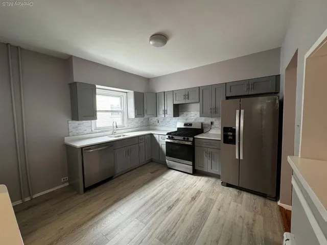 a kitchen with granite countertop a refrigerator stove top oven and sink