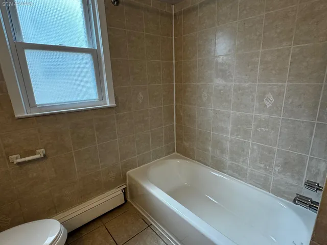 a bath tub sitting next to a white toilet