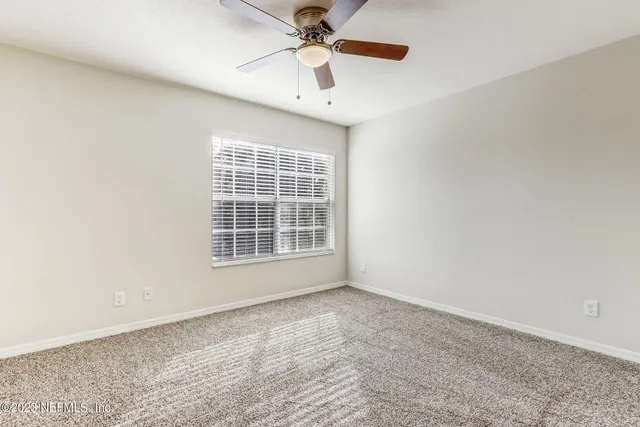 an empty room with closet and windows