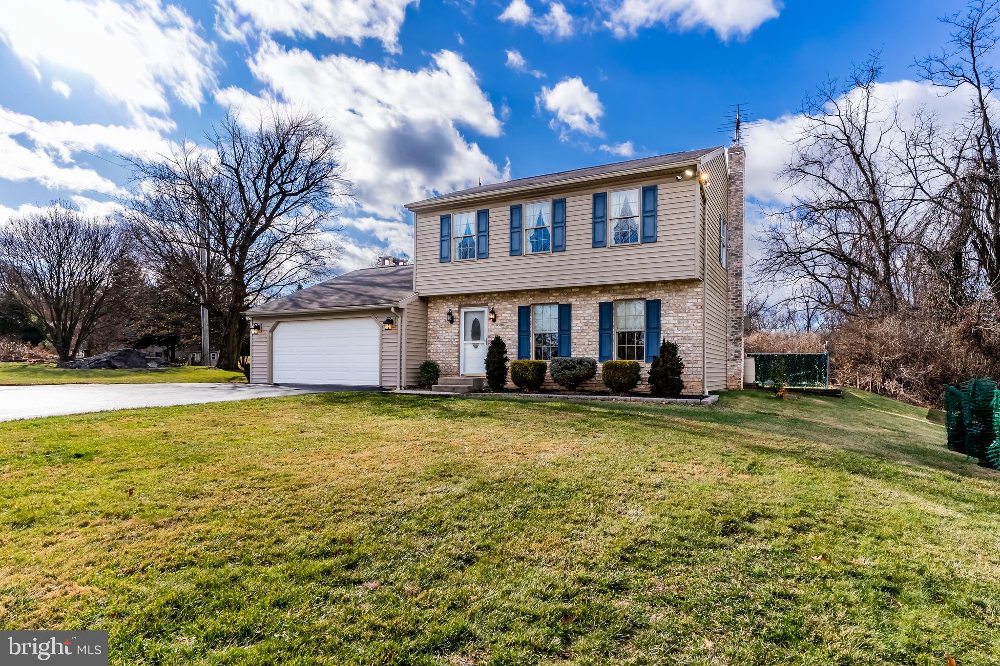 a front view of house with yard and trees in the background