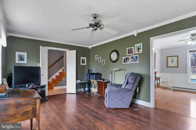 a living room with furniture ceiling fan and a window