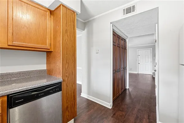 a view of a kitchen with wooden floor and cabinets