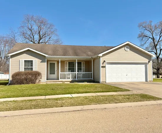 a view of a house with a yard and large tree